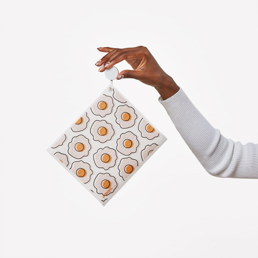 Model holding a hook with a reusable paper towel hanging on it with a cute egg design